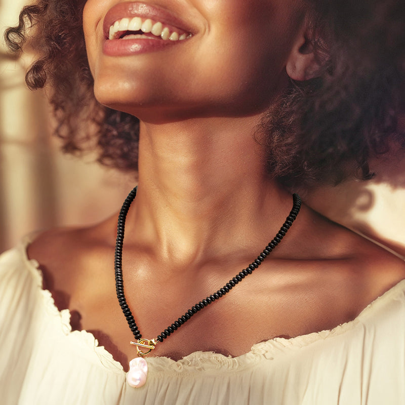 Onyx bead toggle necklace with white baroque pearl and gold clasp on neckline