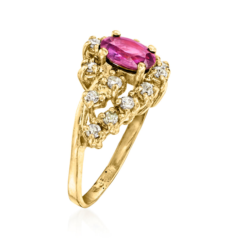 Gold ring with oval pink-red center stone and diamond halo and scrollwork