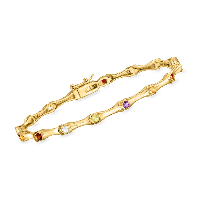 Gold-tone gemstone-studded bangle bracelet with multi-color gems, hinged.