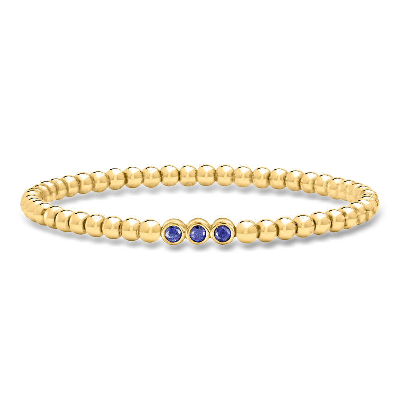 Gold bead stretch bracelet with three blue sapphire accents