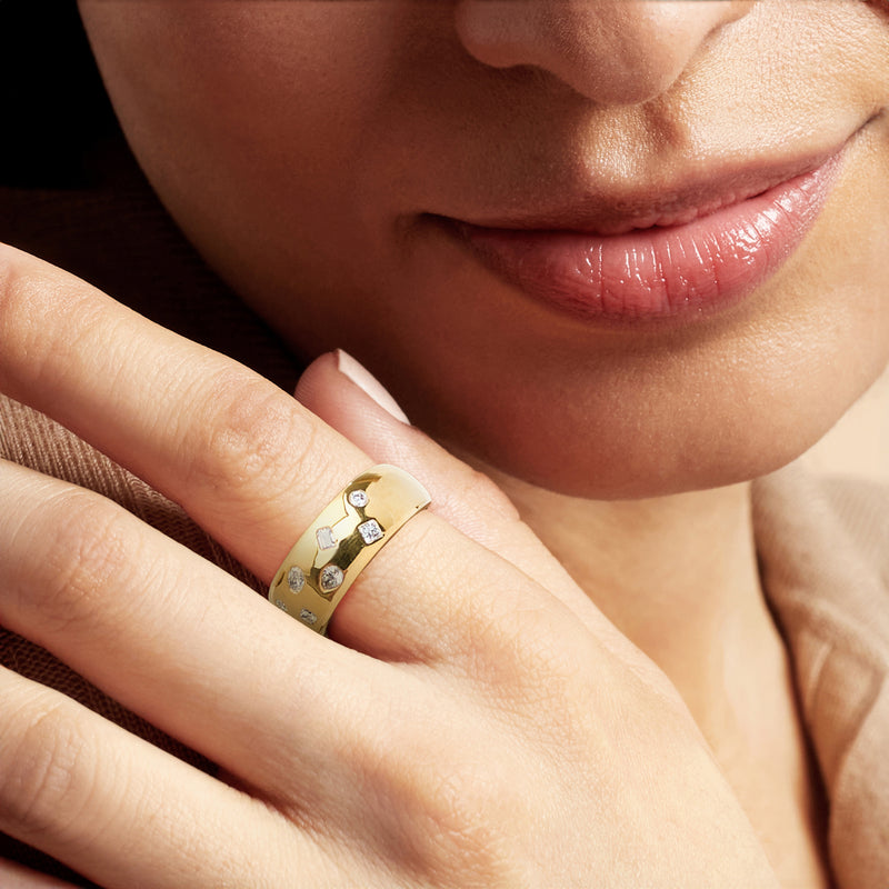 Gold lab-grown diamond ring with mixed round and square stones on finger
