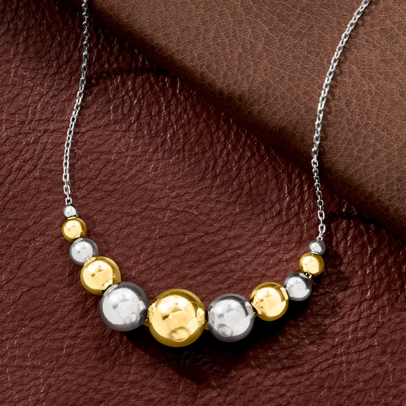 Close-up of graduated round bead necklace: gold center with silver side beads