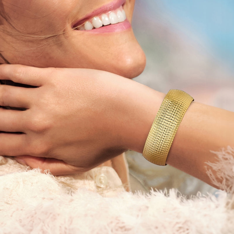 Gold textured bangle bracelet on wrist with polished clasp detail