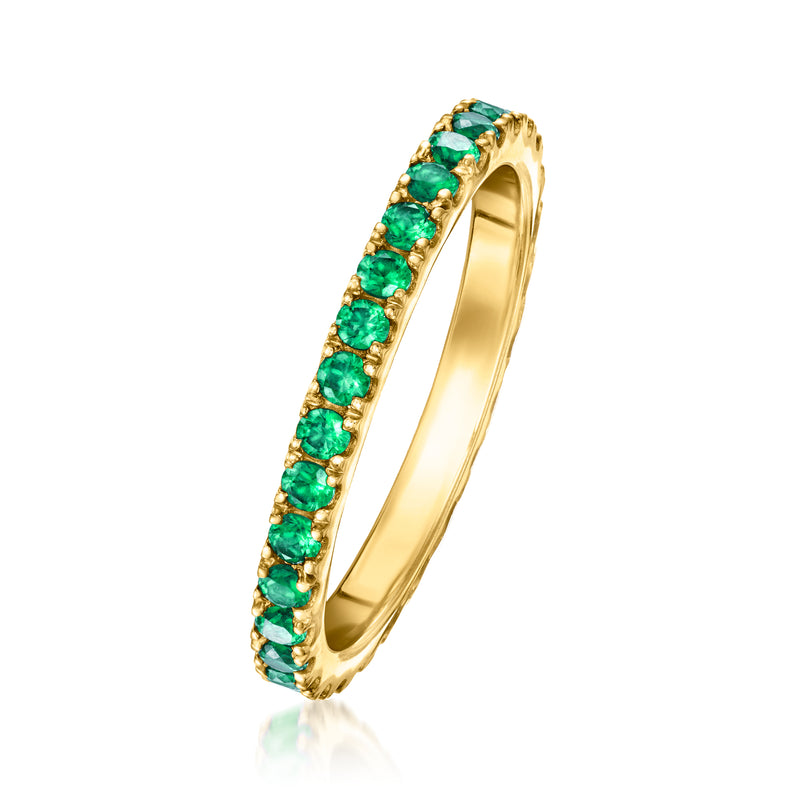 Gold eternity band ring with green emerald-cut stones set in a continuous row