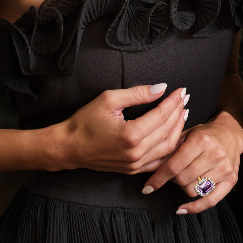 Amethyst cushion-cut ring with diamond halo on hand, gold band