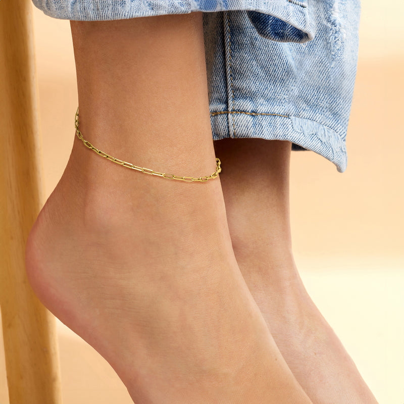 Gold vermeil paper clip link anklet worn on ankle with slim oval-link chain.