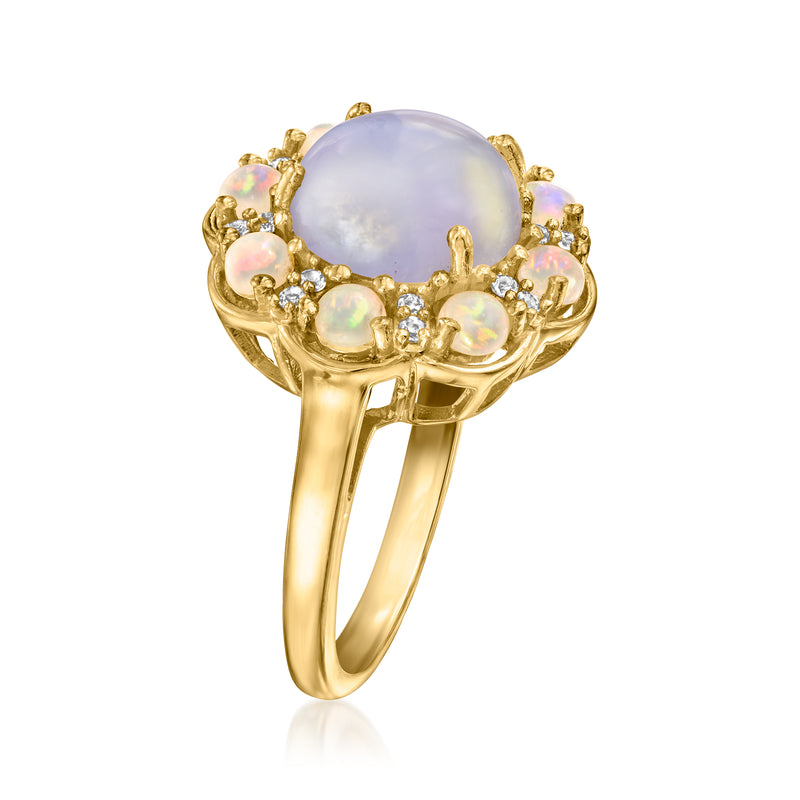 Gold oval-stone ring with prong-set opal-like center, clear halo gems, iridescent side stones