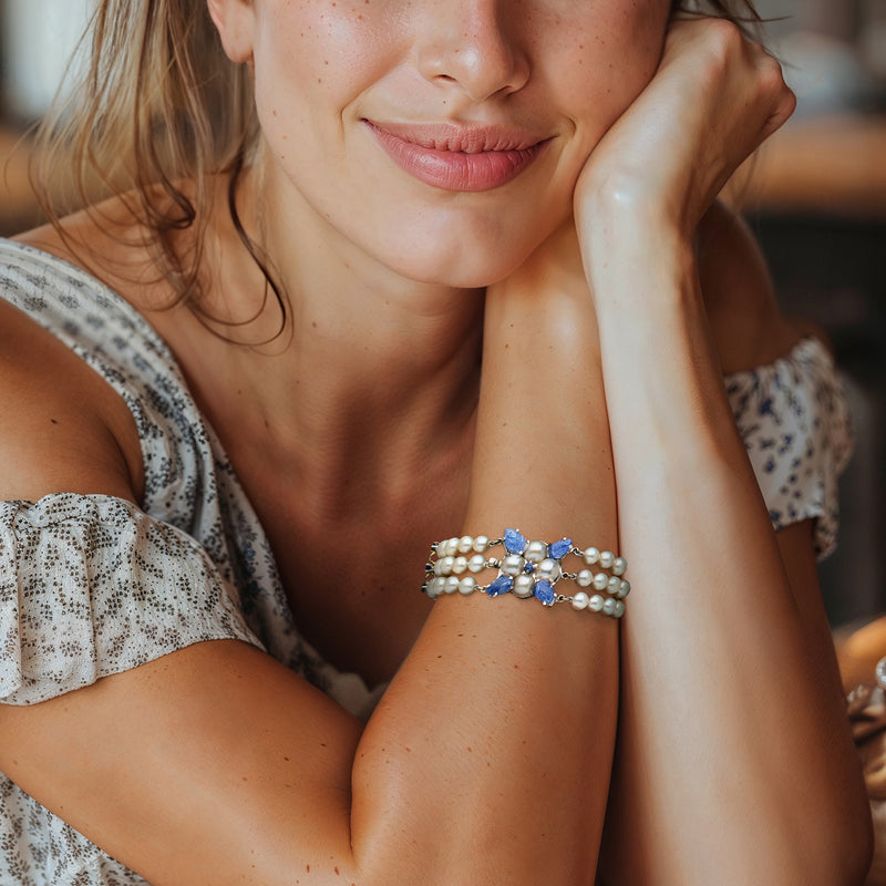 Wrist-worn three-row cultured pearl bracelet with blue sapphire floral links, white gold