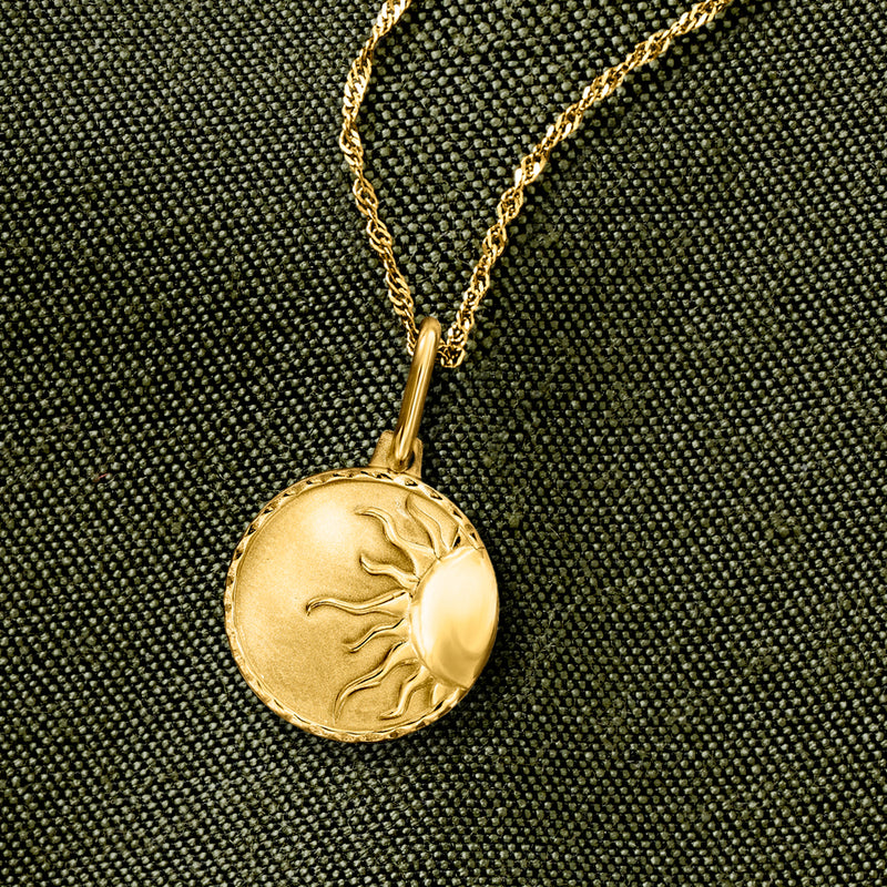 Yellow gold sun charm pendant on a fine chain, round engraved sun face