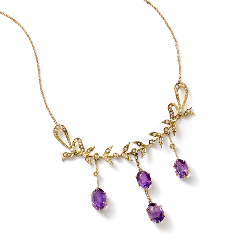 Yellow gold necklace with floral filigree and four purple amethyst drops.