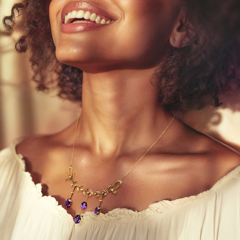 Amethyst drop necklace on model: yellow gold chain with purple gemstone drops.