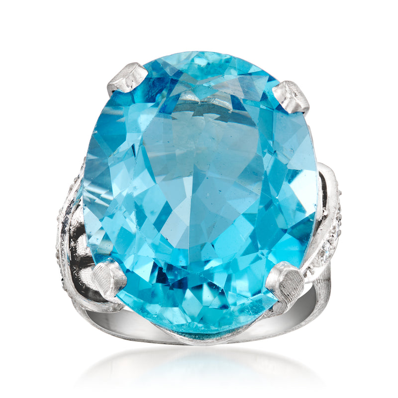 Platinum cocktail ring with large oval aquamarine center stone and small diamond accents