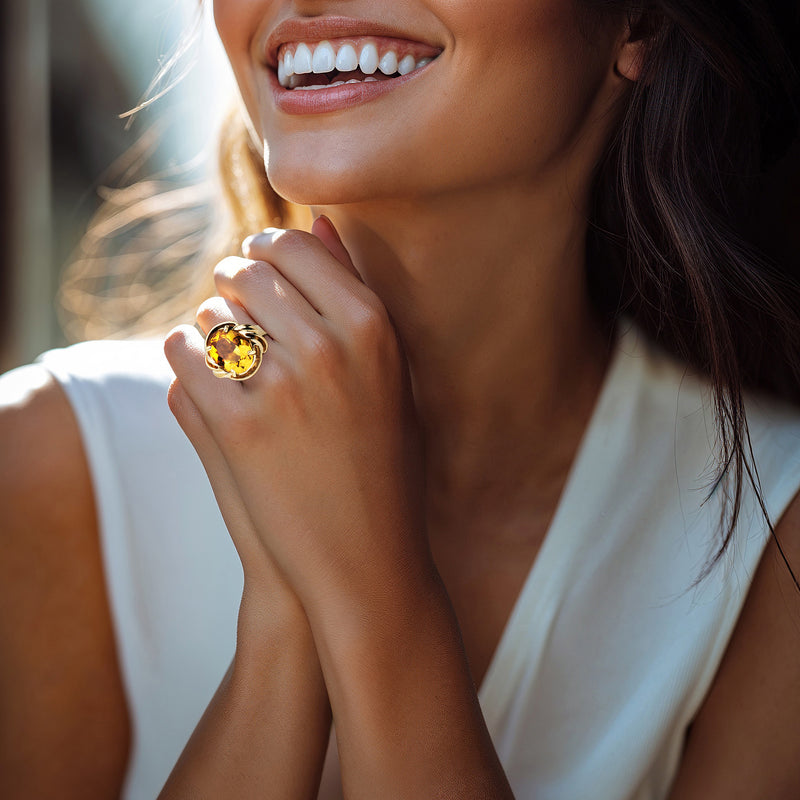 Citrine oval cocktail ring on hand, warm gold setting with ornate shoulders