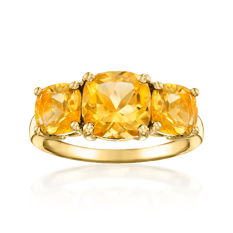 Three-stone citrine ring in gold with oval center and side stones, polished band