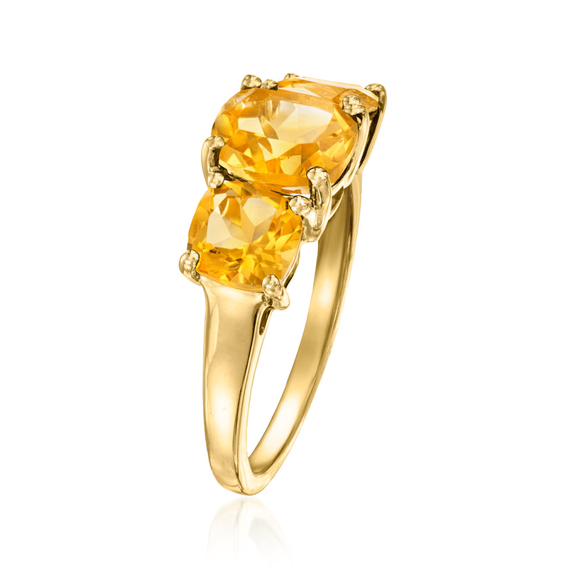 Three-stone citrine ring in gold with elongated oval center stone, slim band