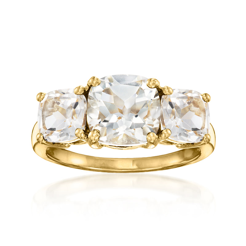 Three-stone white topaz ring with gold band and rounded bezel settings
