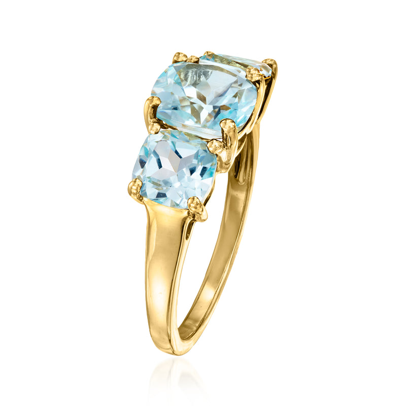 Sky blue topaz three-stone ring, angled view, oval stones in gold bezel setting