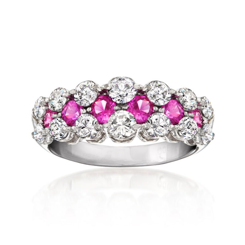 Platinum ring with pink sapphire stones and diamond accents on a polished band