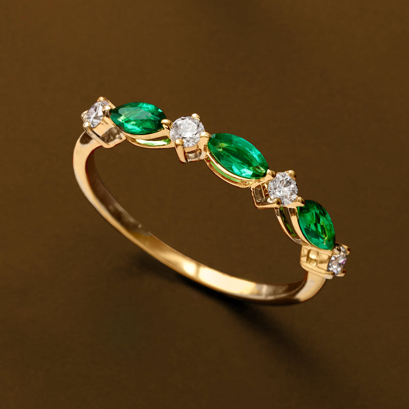Gold vermeil ring close-up of emerald-green oval stones with round diamond accents