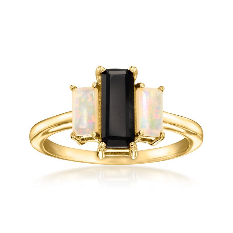 Gold-tone ring with black onyx center and white opal side stones, raised rectangle design