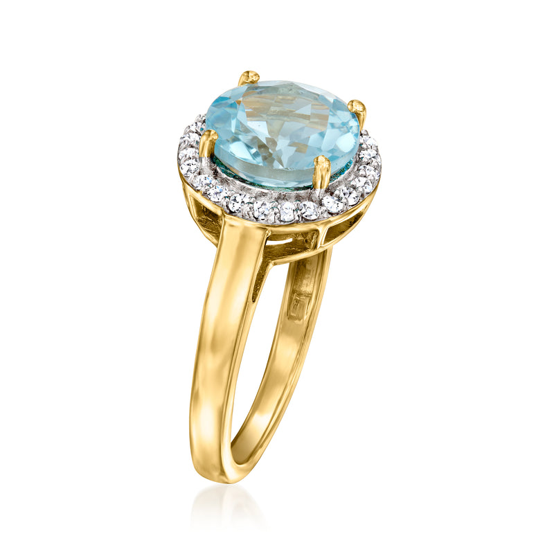 Gold ring featuring oval sky blue gemstone in center with diamond halo and side prongs