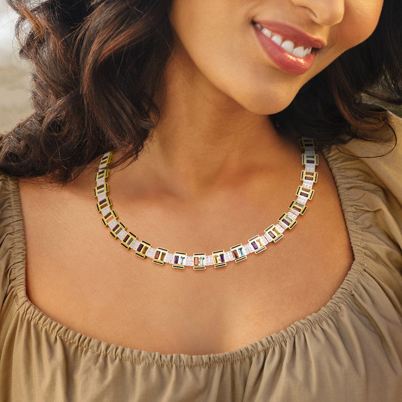 Art Deco-style gold-tone necklace with multicolor square stones and black enamel, worn