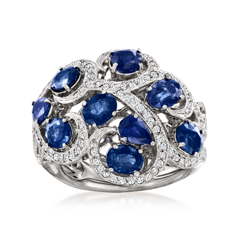 Swirl sapphire and diamond ring in white metal with oval blue stones and round accents