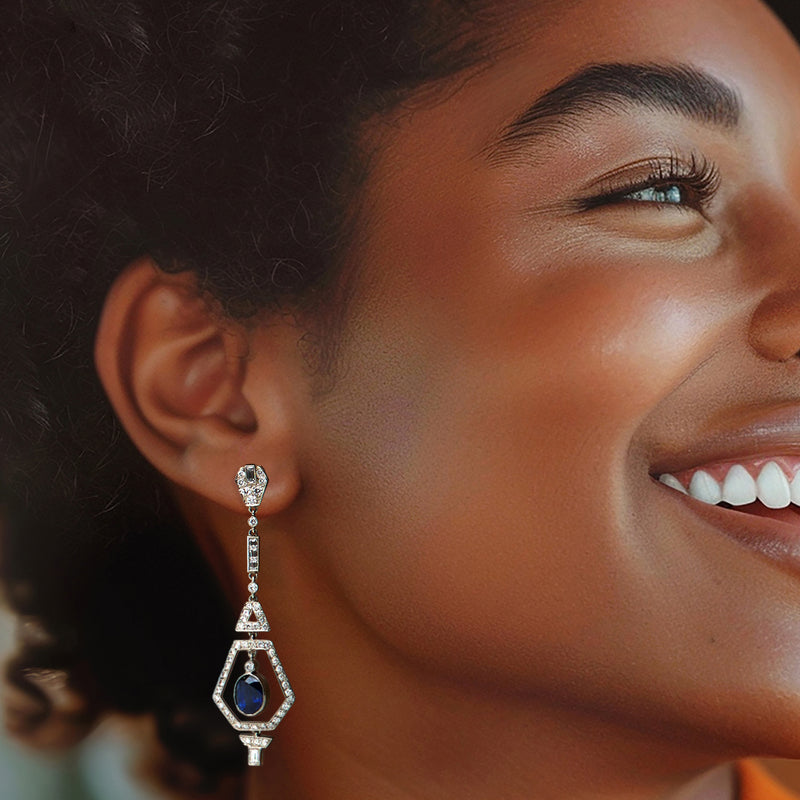 Platinum geometric sapphire and diamond drop earrings on model, blue oval center