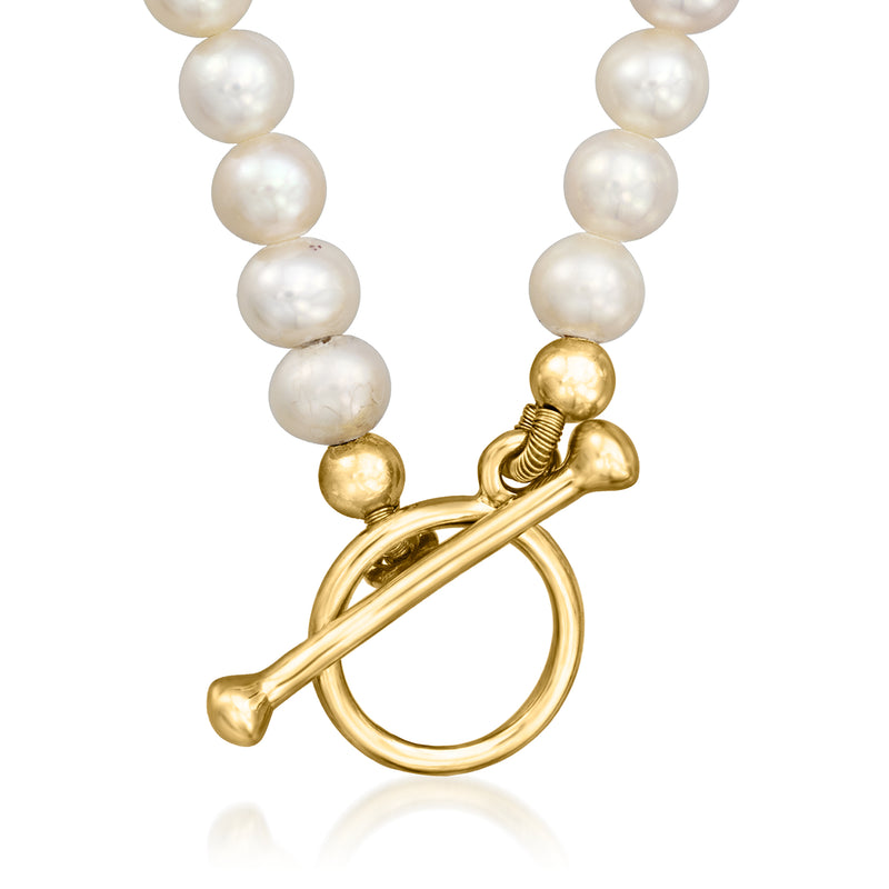 Cultured pearl toggle necklace featuring gold toggle clasp and flower charm with stones.