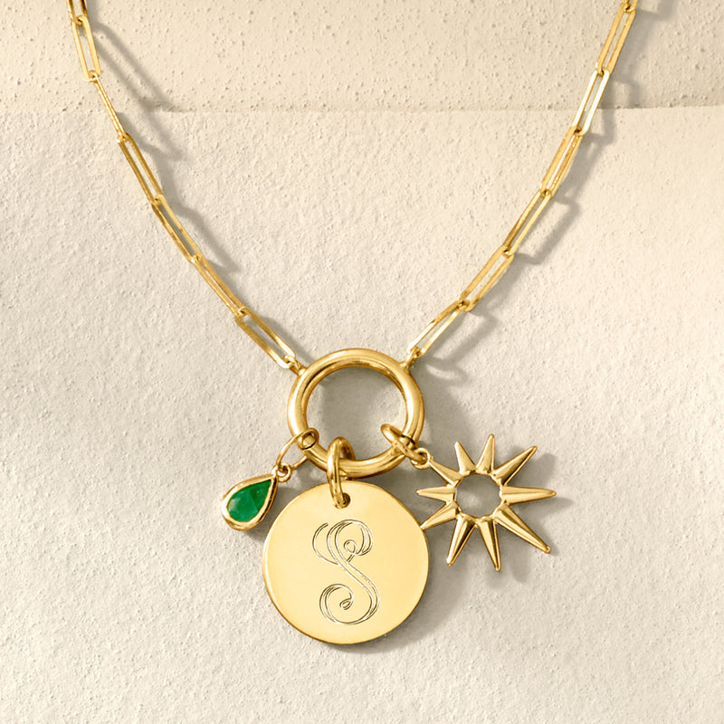 Yellow gold disc charm with engraved S initial, plus star and green enamel accents