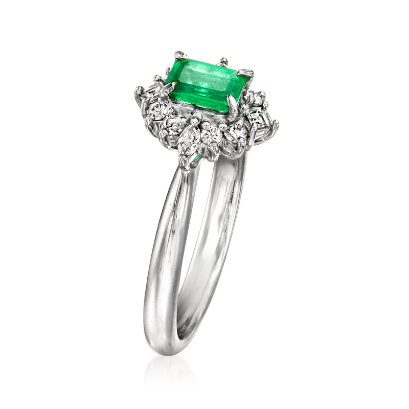 Platinum ring with rectangular emerald-cut green center stone and diamond cluster sides
