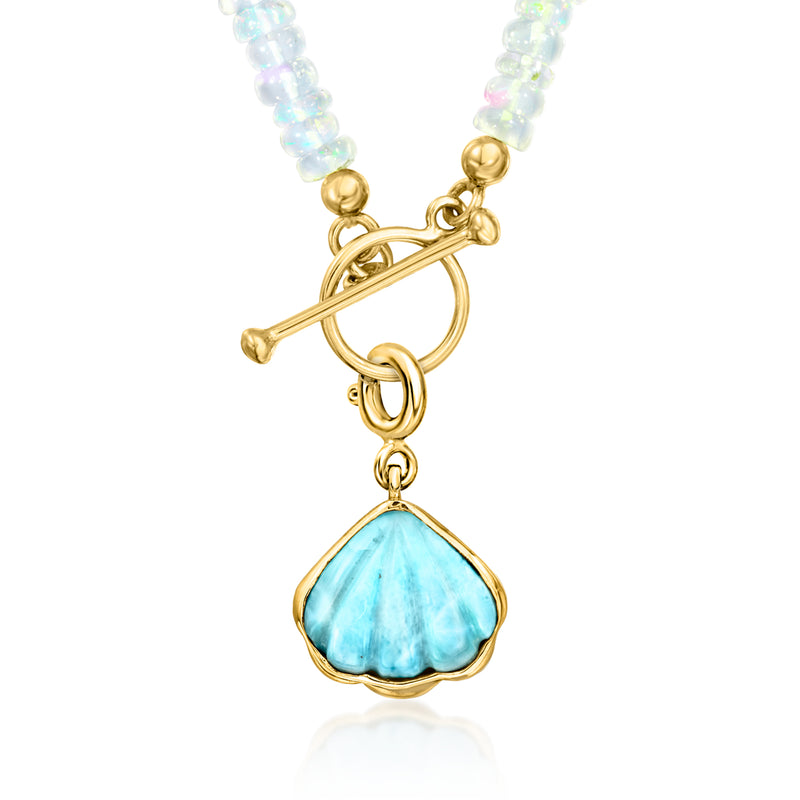 Gold-tone seashell charm with light blue larimar drop on a beaded necklace