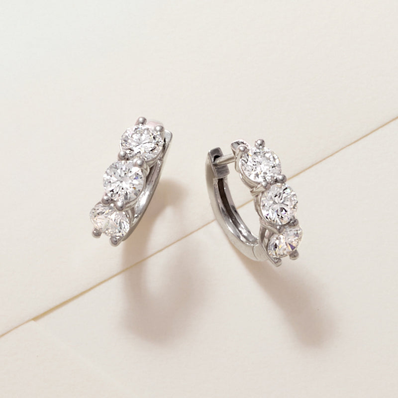 Platinum huggie hoop earrings with three round diamond accents