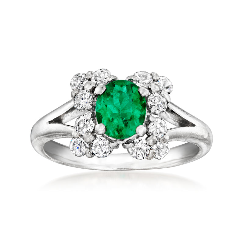 Platinum cocktail ring with oval green emerald center and round diamond halo