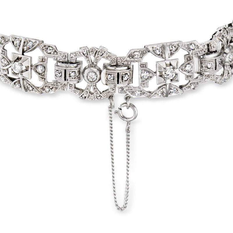 Platinum diamond bracelet with repeating geometric links and a small dangling chain