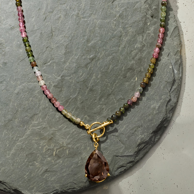 Tourmaline bead necklace with gold toggle clasp and large brown teardrop charm.
