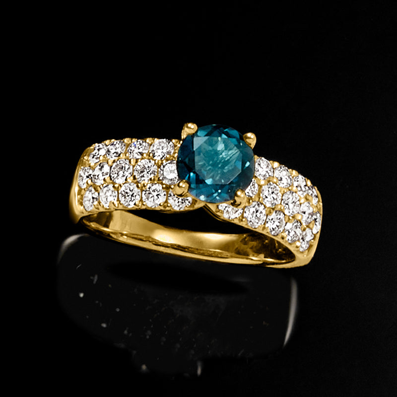 Gold ring featuring London blue topaz center flanked by round lab-grown diamonds