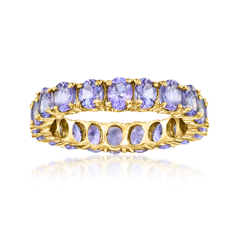 Gold eternity band ring with oval tanzanite-colored gemstones and scalloped prong settings