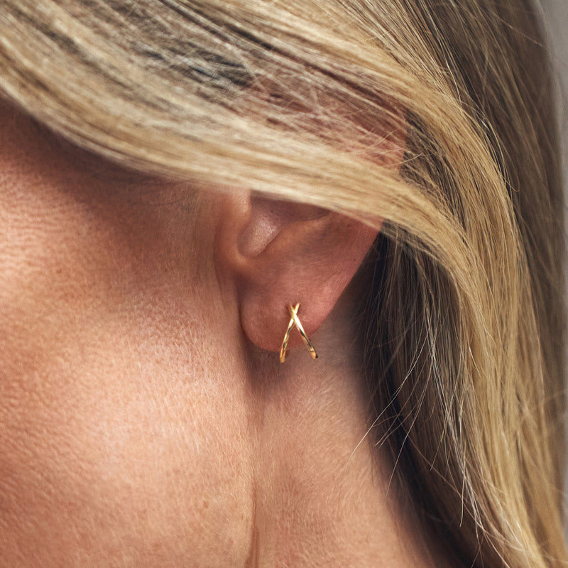 Yellow gold split C-hoop earring on ear, small open arch with post
