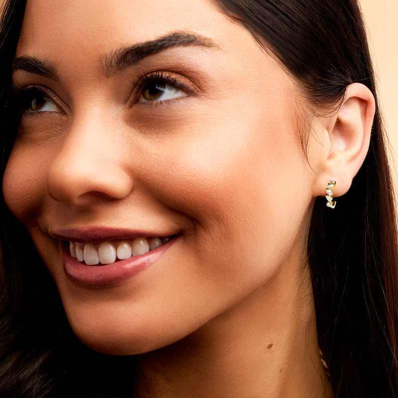 Model wearing gold vermeil hoop earrings with sparkling multi-stone diamond accents