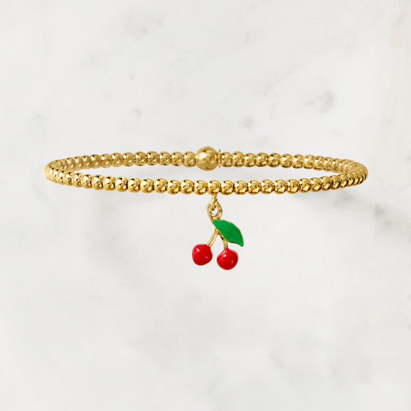 Gold bead stretch bracelet with enamel cherry charm, side view