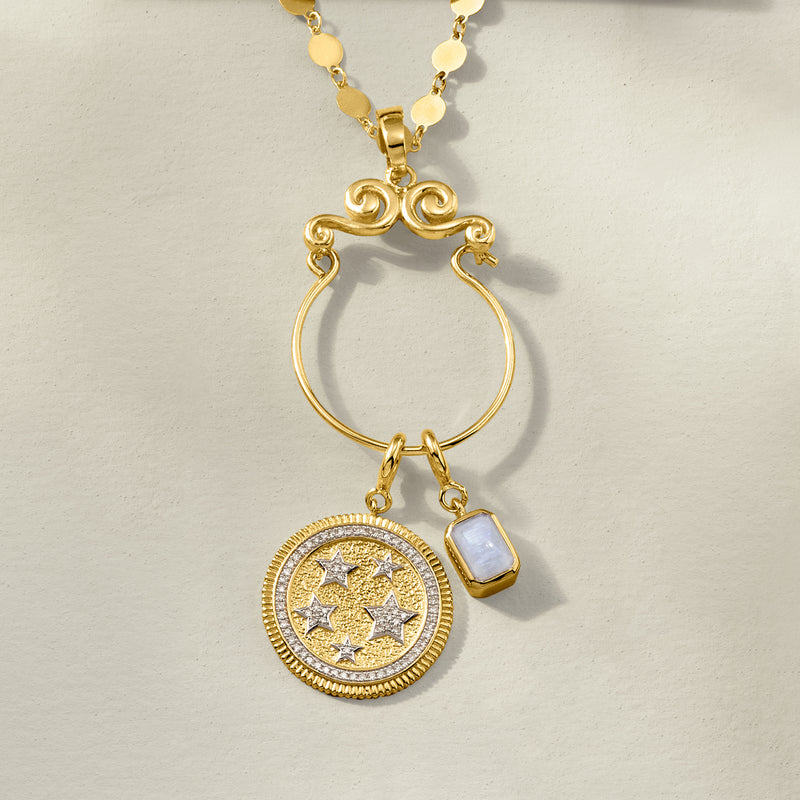 Gold charm holder pendant with scroll top, open ring, star coin medallion, and cube charm