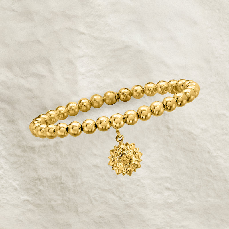 Gold beaded stretch bracelet with sunflower charm drop
