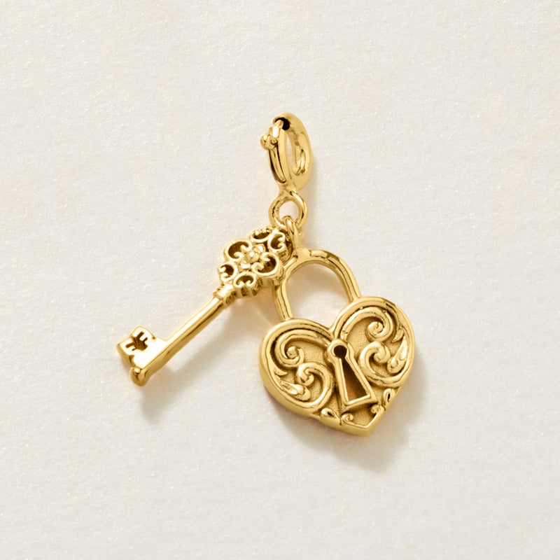 Gold-tone heart lock charm with key dangle and scrollwork details
