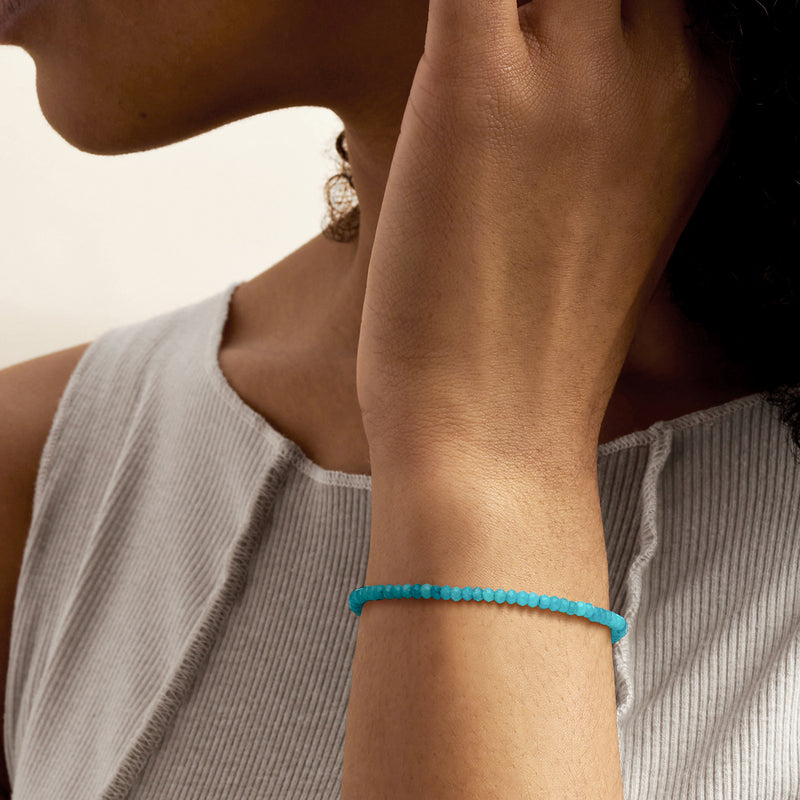 Blue round-bead bracelet band, worn on wrist