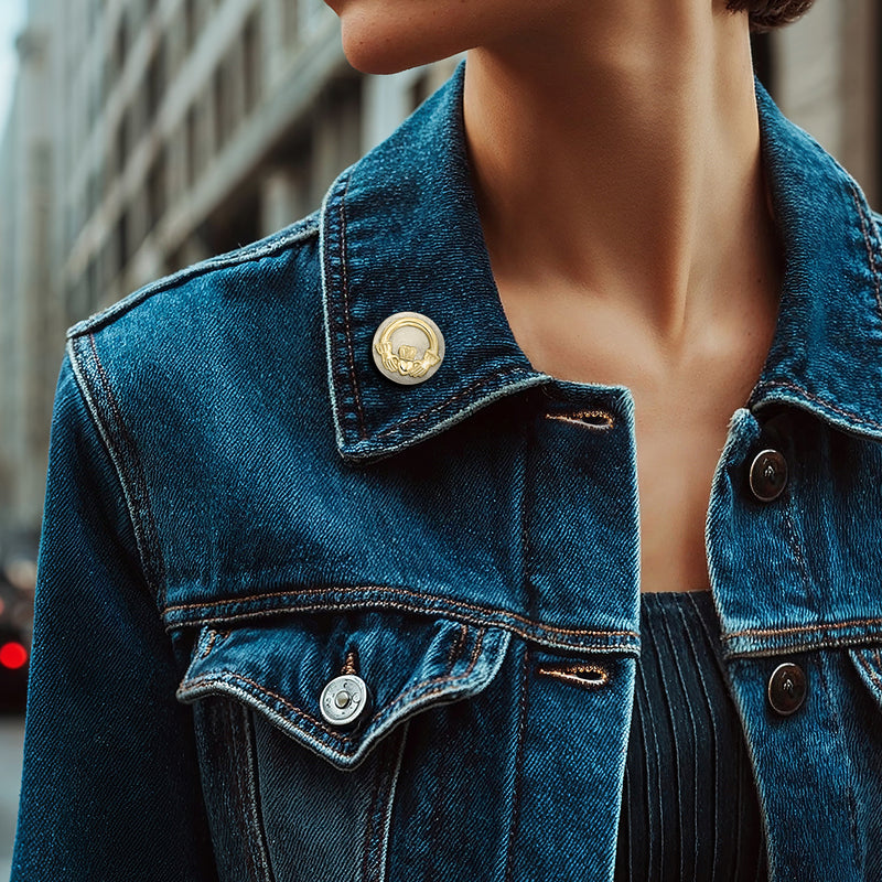 Two-tone 14kt gold Claddagh pin on blue denim jacket, round clasp