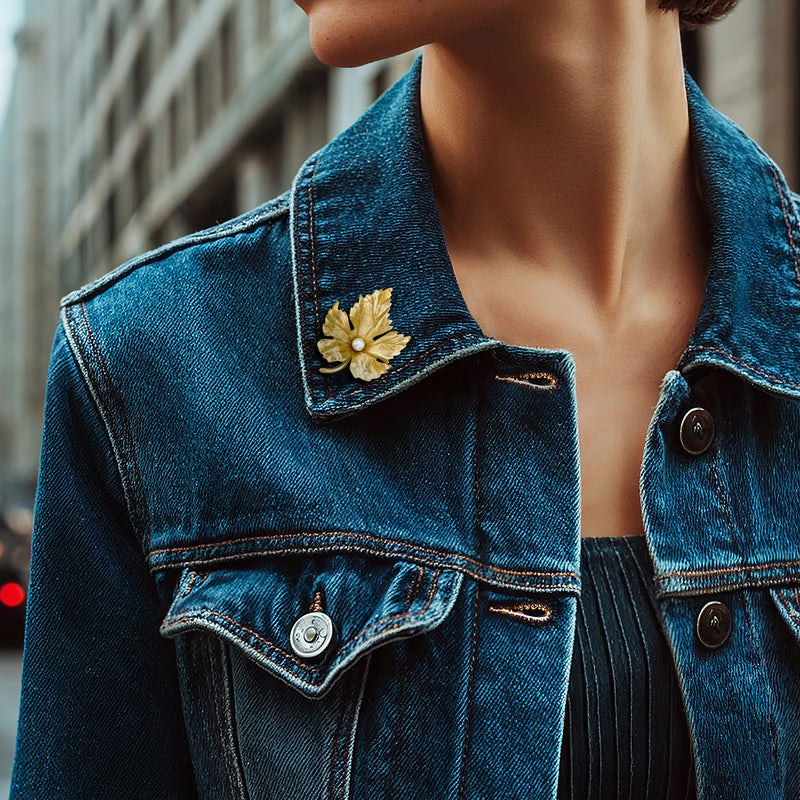 Gold leaf cultured pearl pin on blue denim jacket collar