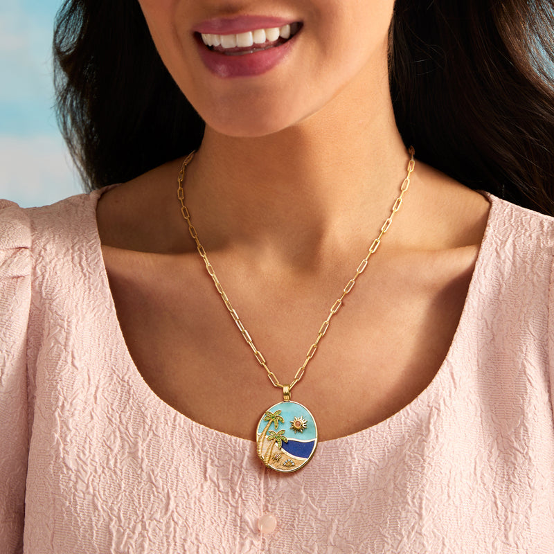 Gold chain link necklace with round ocean pendant featuring palm trees and sun charm