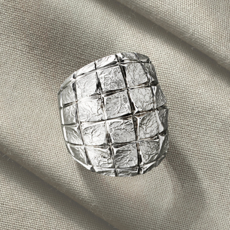 Sterling silver ring close-up, square grid texture with hammered finish.