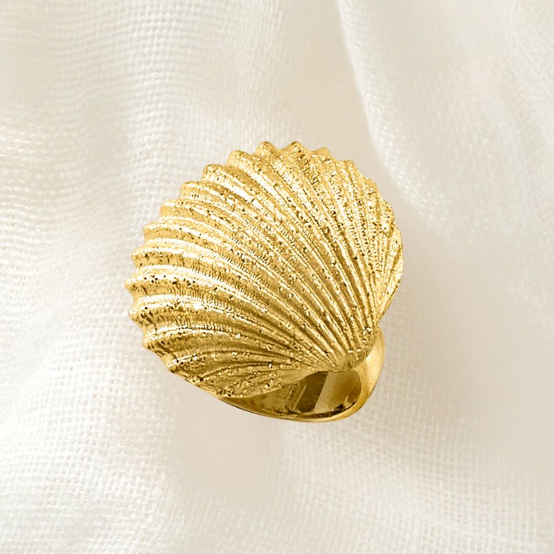 Gold seashell ring on finger, ridged shell head with band showing